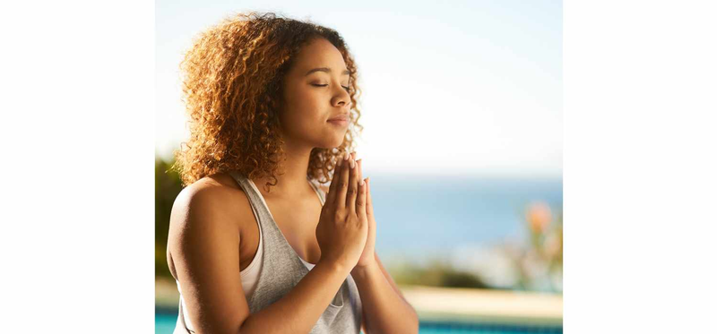 Cropped shot of an attractive young woman meditating outdoors.