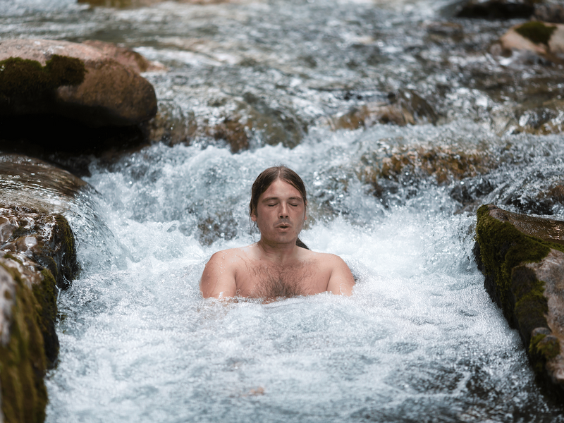 man in icy cold water stream