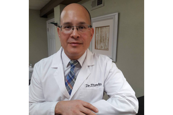 Headsot of Dr. Jason Tirado in his lab coat