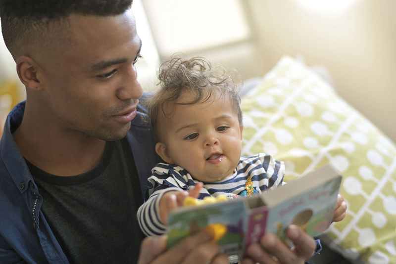 Parent reading book to baby