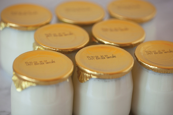 Glass bottles of milk with food labels of expiration dates on top