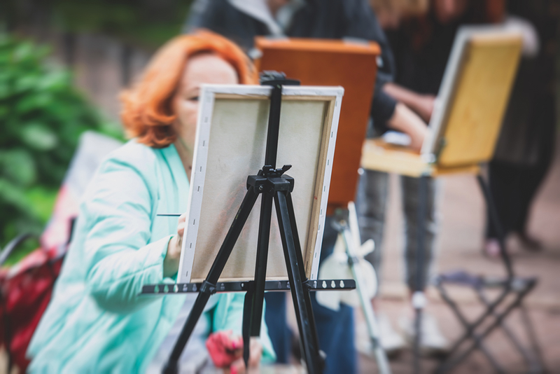 Artists painting on canvas on easels outdoors