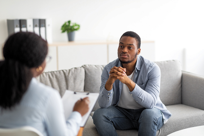 Person sitting on couch across from mental health therapist