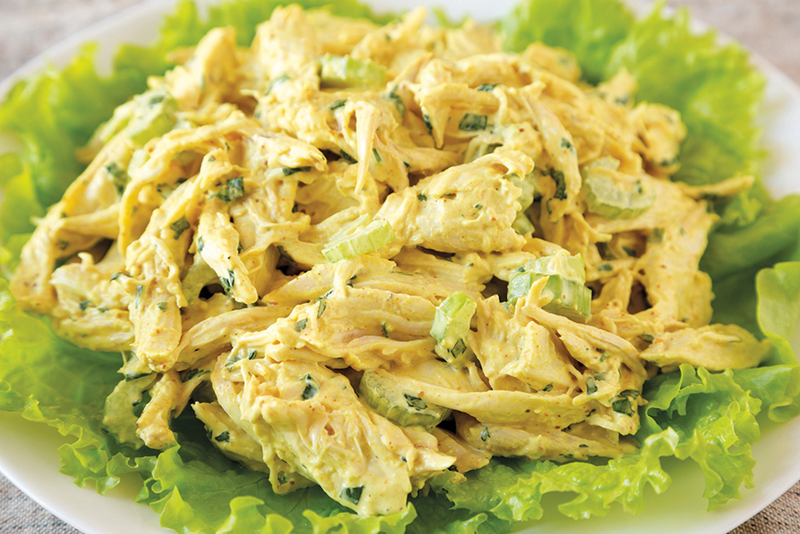 Plate of chicken curry salad on top of lettuce